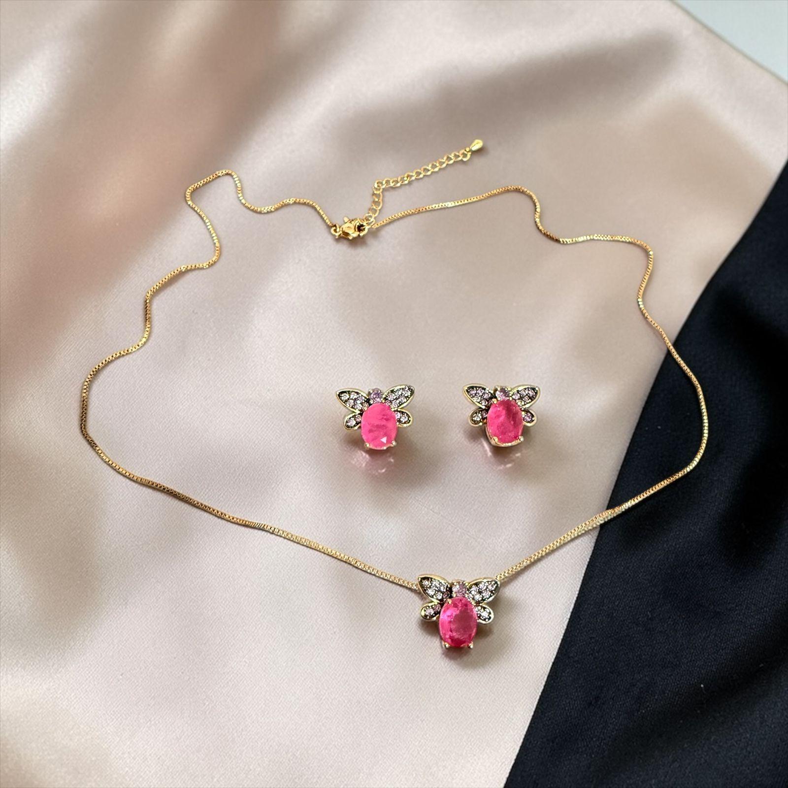 Conjunto Borboleta Encantada Descrição: Conjunto delicado com pedra rosa central e detalhes em microcristais formando asas de borboleta. Uma peça charmosa e feminina que simboliza leveza e beleza.