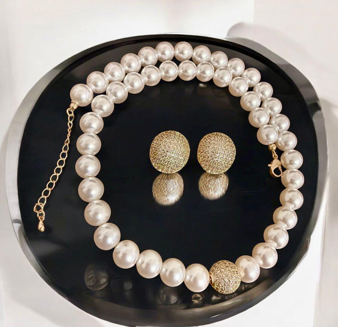 Conjunto Clássico Chic Descrição: Colar de pérolas com toque moderno e brincos harmonizados, perfeito para valorizar looks atemporais com sofisticação.