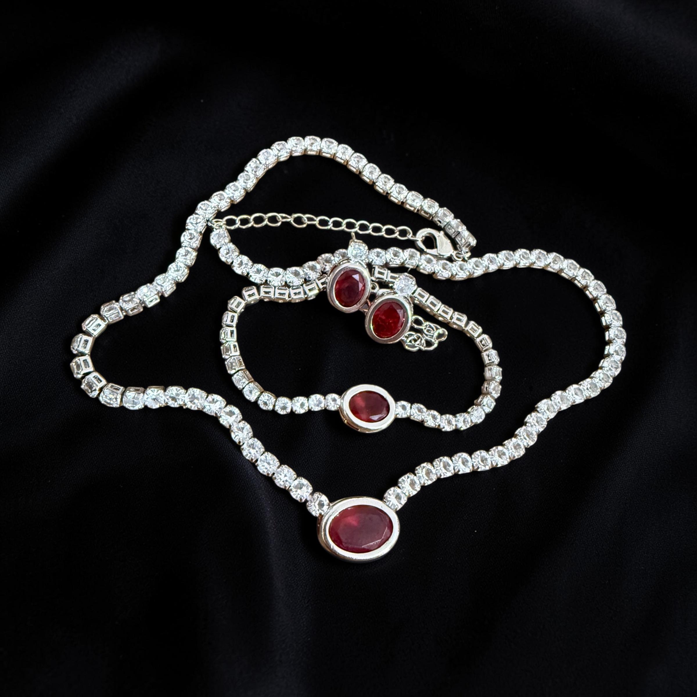 Conjunto Rubi Imperial Descrição: 
Riviera cravejada com pedra central vermelha intensa, transmitindo luxo e presença marcante.