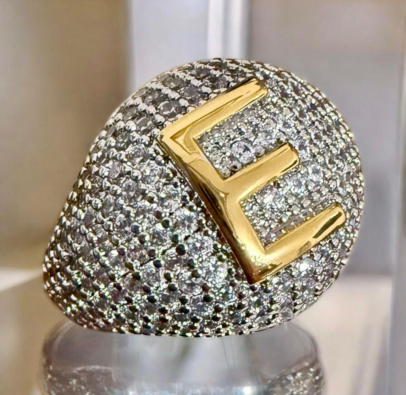 Anel Monograma E Glam - aro 14 Descrição: Anel totalmente cravejado com zircônias cintilantes e inicial E em alto relevo, finalizada em banho dourado. Ideal para quem valoriza exclusividade, elegância e presença.