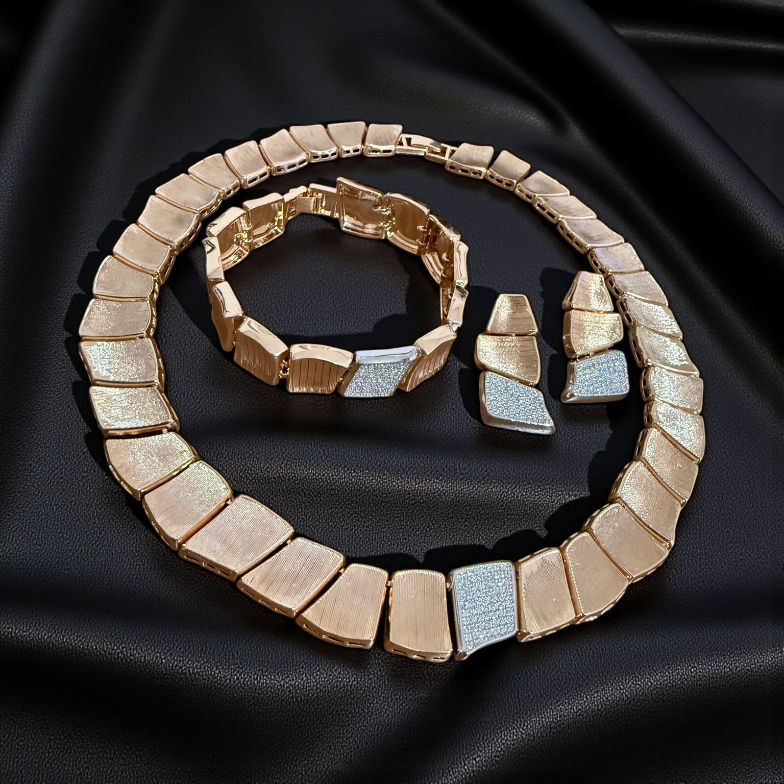 Conjunto Geométrico Dourado Descrição: (colar + pulseira + brincos)


Colar, pulseira e brincos co, design moderno com placas estruturadas e contraste de texturas que transmite elegância contemporânea