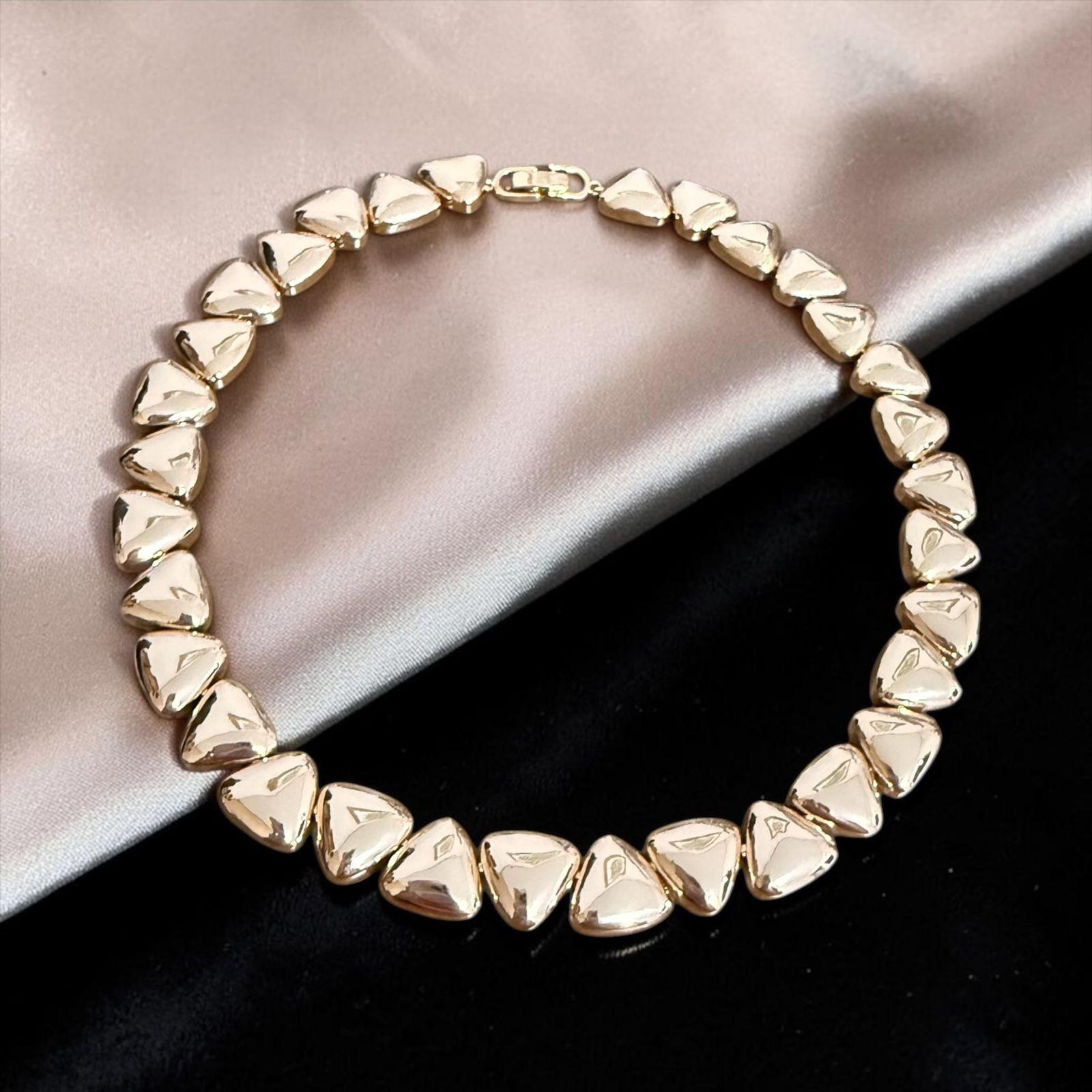 Colar Triângulos Imperiais Descrição: Colar com design sofisticado composto por elementos triangulares em acabamento dourado polido, que criam um visual moderno e marcante. Uma peça elegante e imponente, perfeita para destacar o colo com estilo, personalidade e um toque de luxo contemporâneo.
