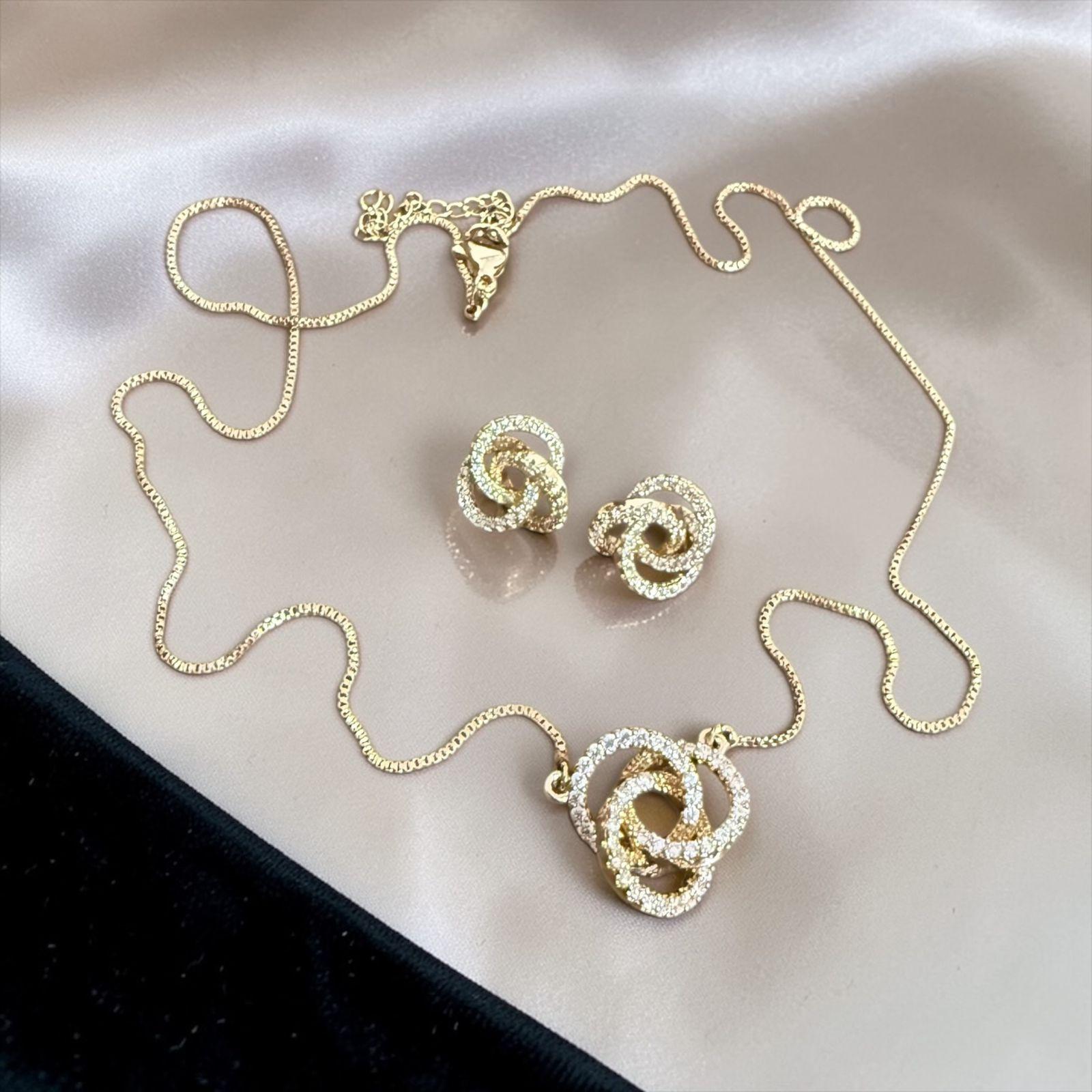 Conjunto Laço de Luz Descrição: Formas entrelaçadas com microcravação que refletem brilho suave e sofisticado. Um conjunto delicado e elegante, perfeito para compor looks com leveza e estilo.