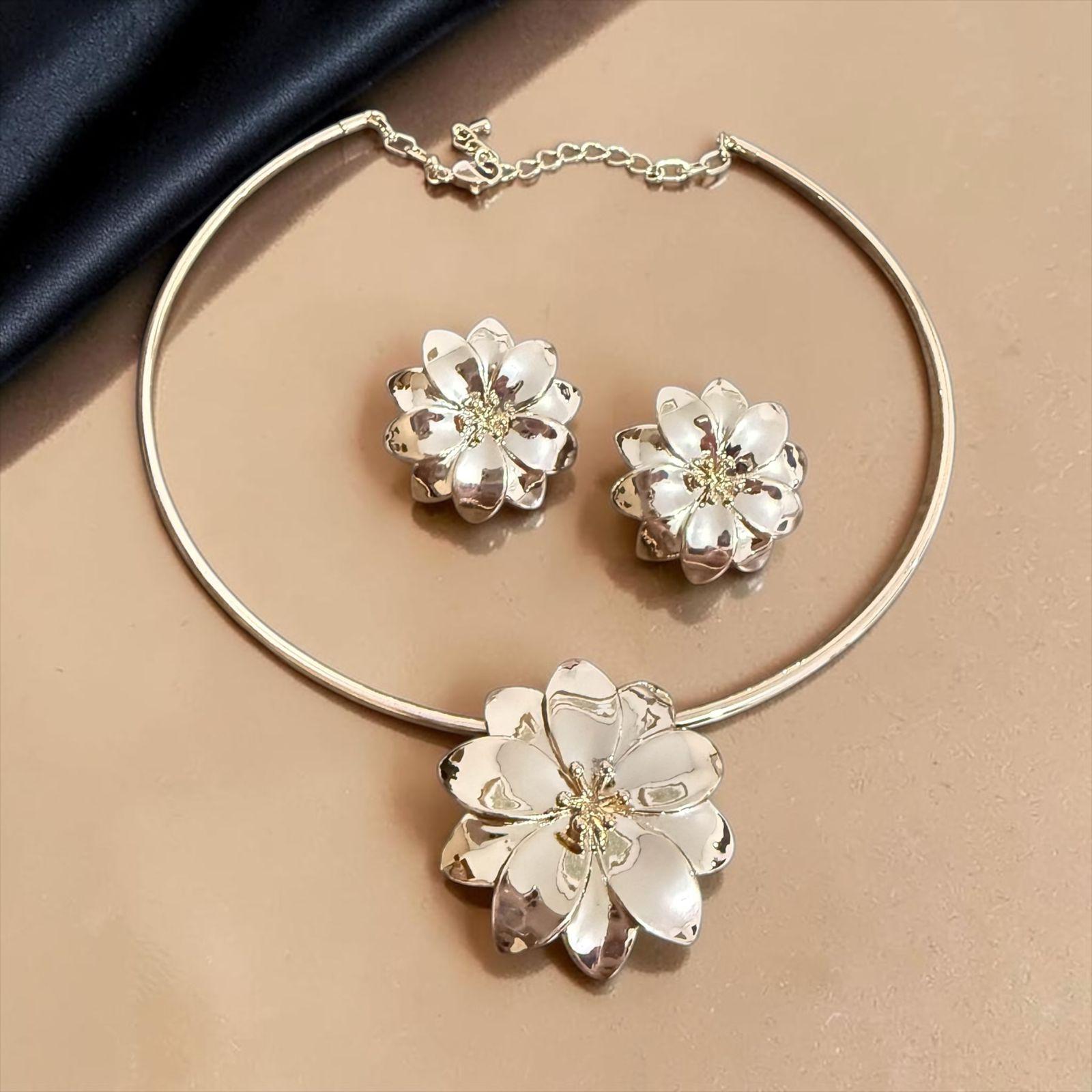 Conjunto Flor de Luz Descrição: Conjunto composto por colar e brincos com delicado design floral em acabamento polido, que reflete a luz com elegância e suavidade. Uma composição sofisticada e feminina, perfeita para realçar a beleza natural com um toque de leveza, charme e exclusividade.