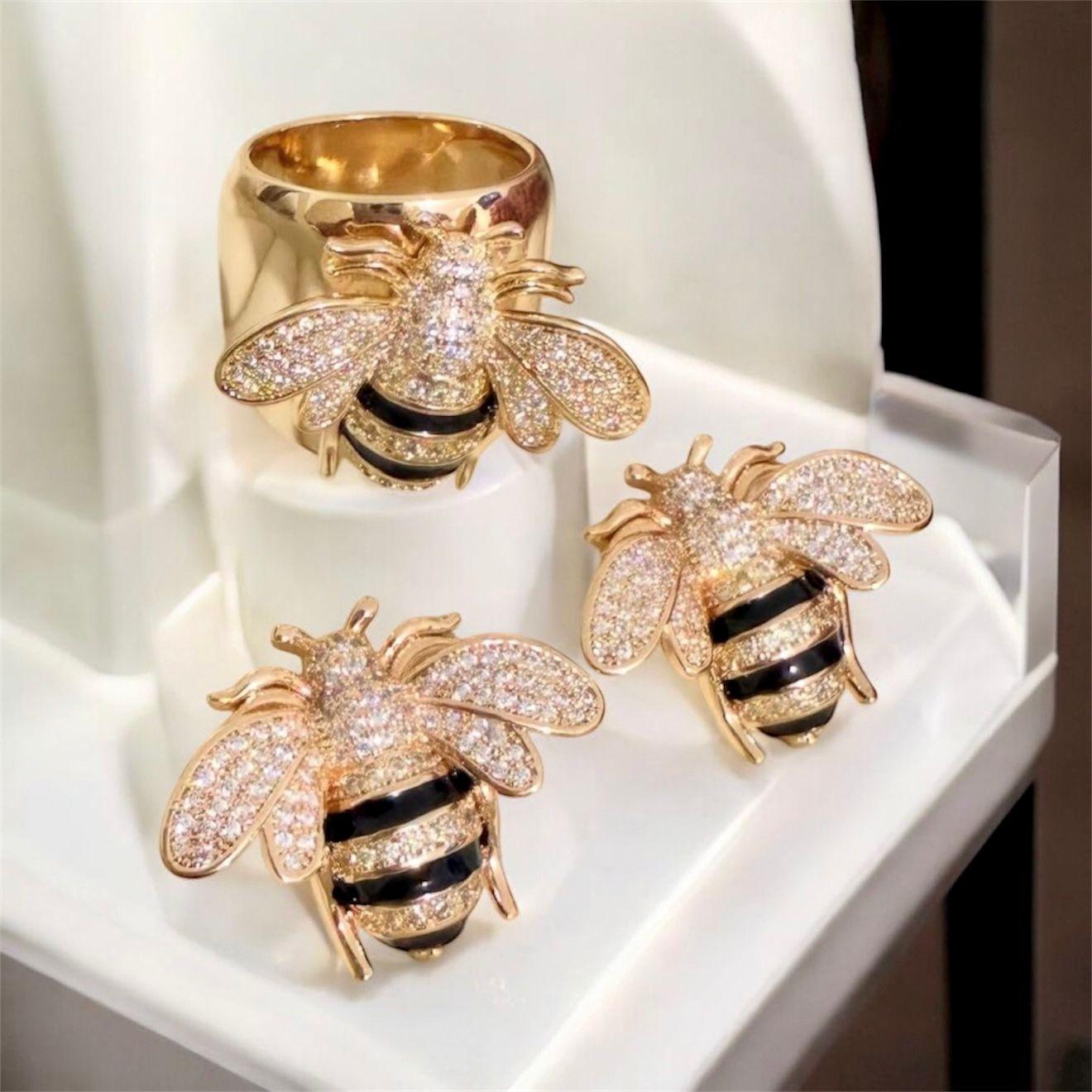 Conjunto Abelha Majestade - anel aro 19 Descrição: Conjunto sofisticado com design de abelha em banho dourado, cravejado com zircônias e detalhes em preto esmaltado, traduzindo luxo, força e elegância contemporânea.