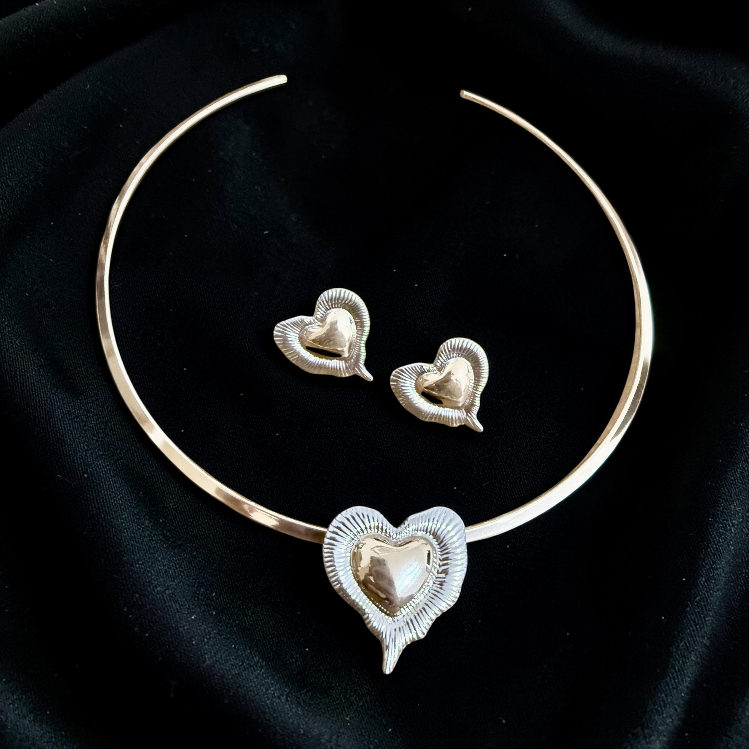 Conjunto Amor Sublime Descrição: 
Choker minimalista com coração central e brincos delicados, romântico e elegante. Com duo de banho.