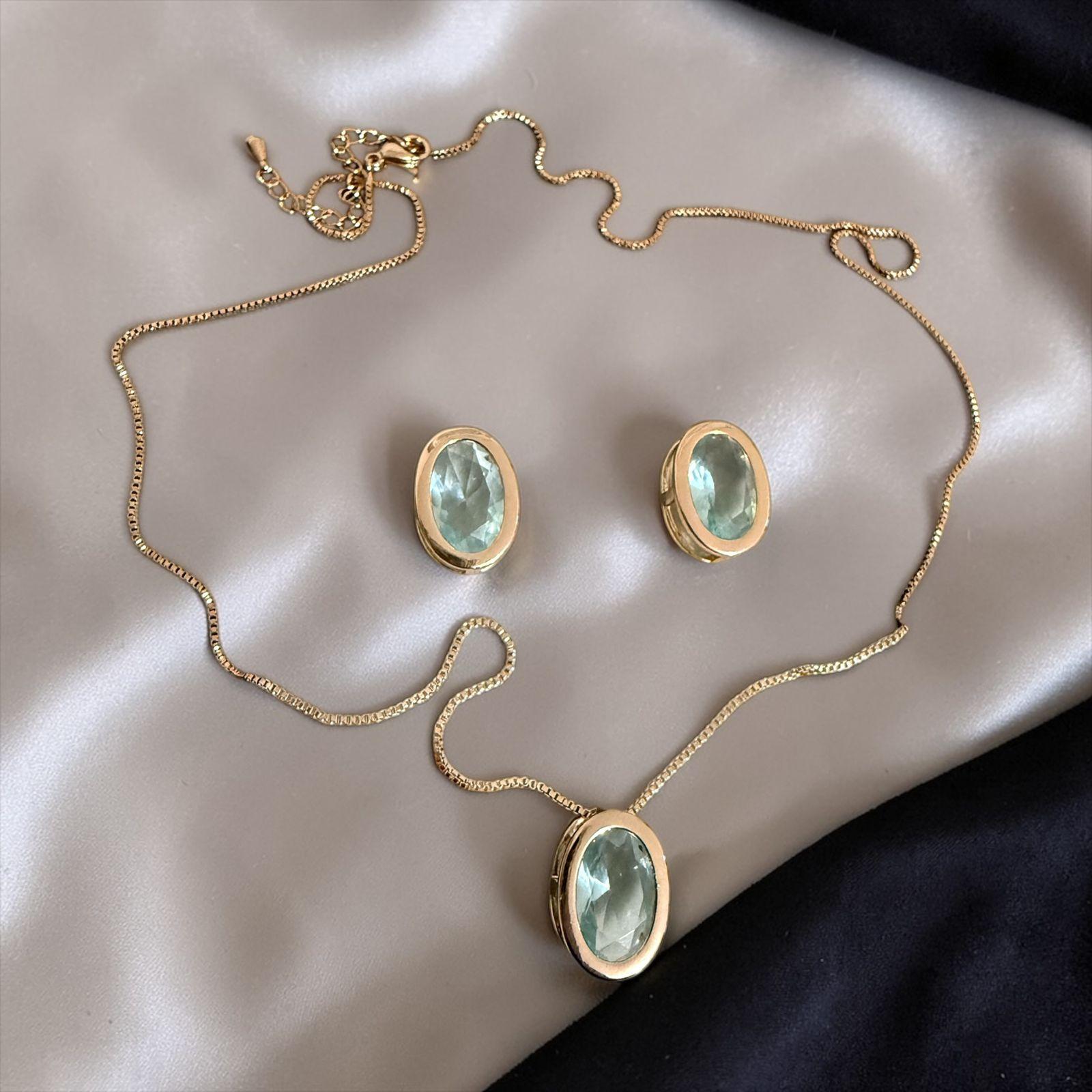 Conjunto Aura Verde Descrição: Conjunto sofisticado com pedra oval verde água lapidada e acabamento dourado polido. Uma peça elegante e atemporal que ilumina o visual com delicadeza e sofisticação.