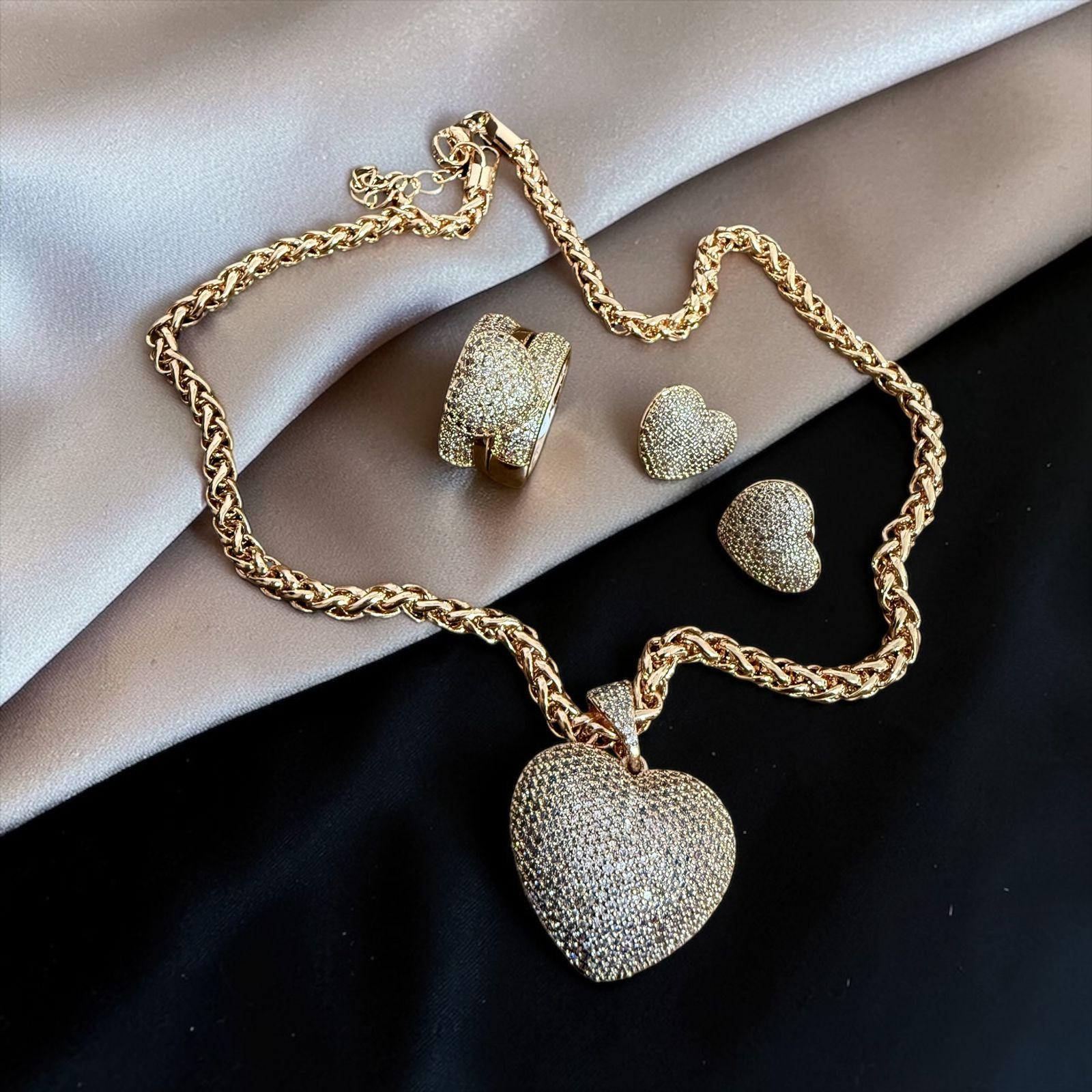 Conjunto Amor Radiante - Anel aro 20 Descrição: Conjunto sofisticado com colar de corrente robusta e pingente de coração totalmente cravejado, acompanhado de brincos delicados. Uma peça marcante e cheia de brilho.