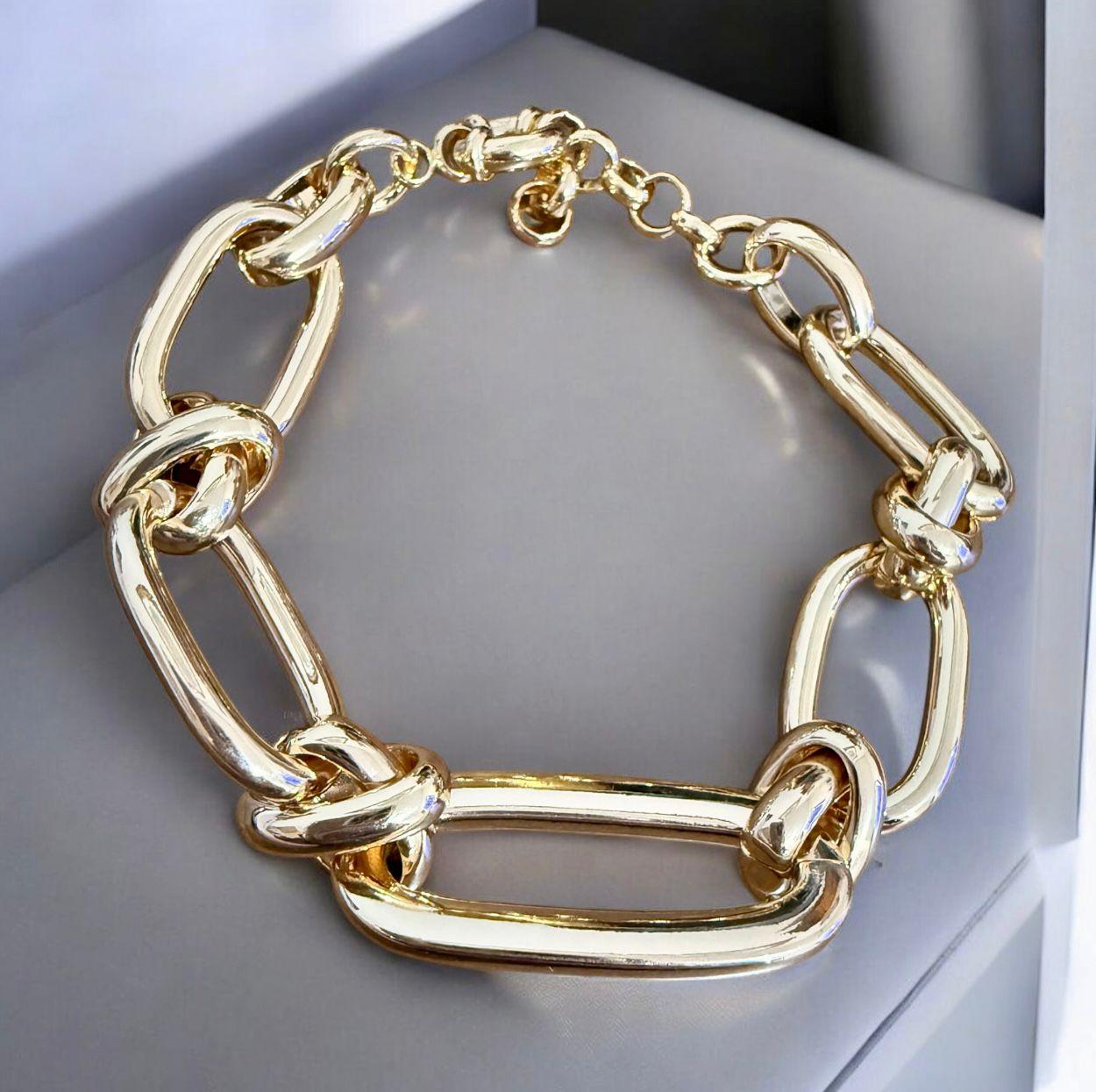 Pulseira Elo Lux Descrição: Pulseira em banho dourado com elos ovais robustos e elo central alongado, criando um visual sofisticado e de presença marcante.