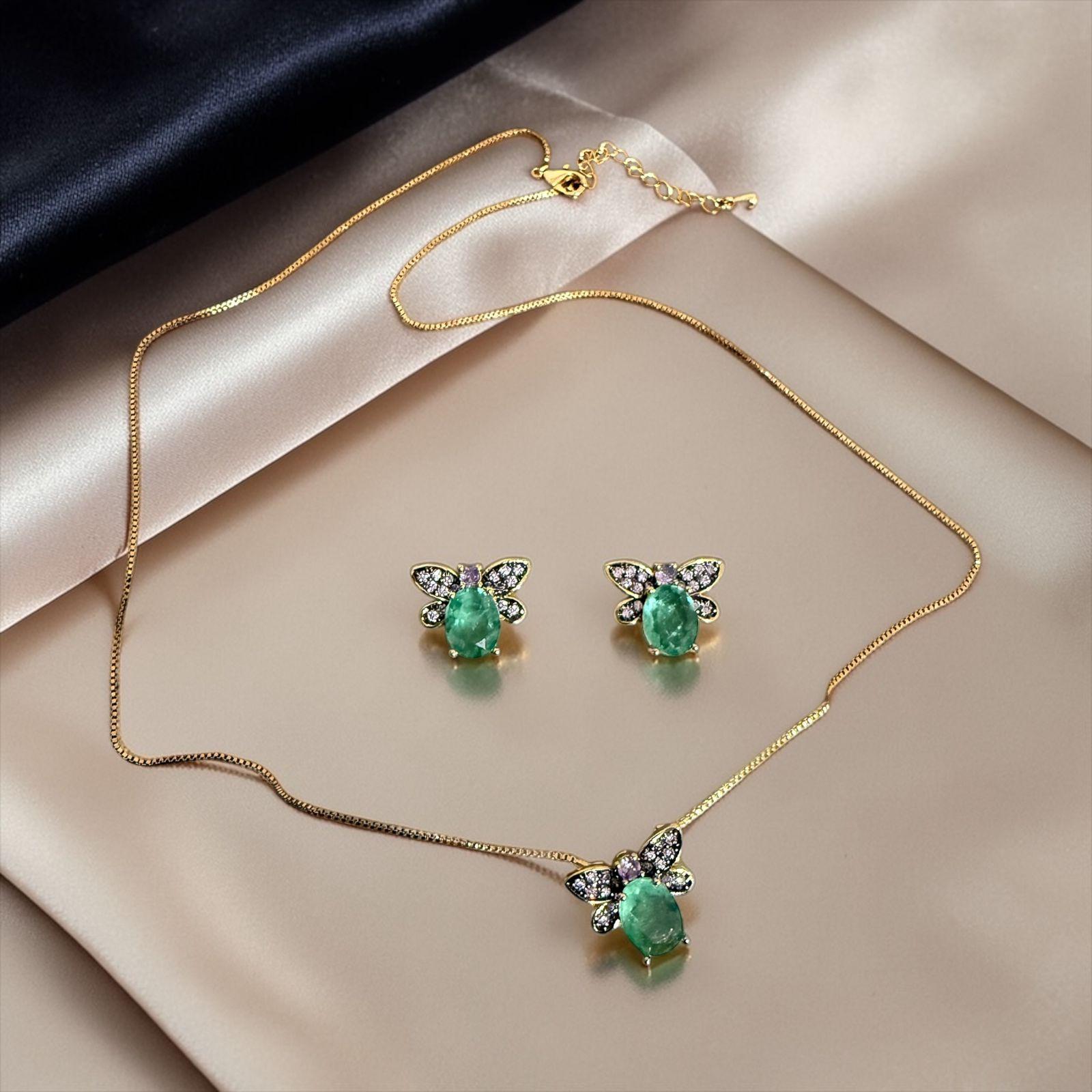 Conjunto Borboleta Esmeralda Descrição: Conjunto sofisticado com pedra verde central e delicadas asas de borboleta cravejadas. Uma joia que combina elegância com um toque de natureza.