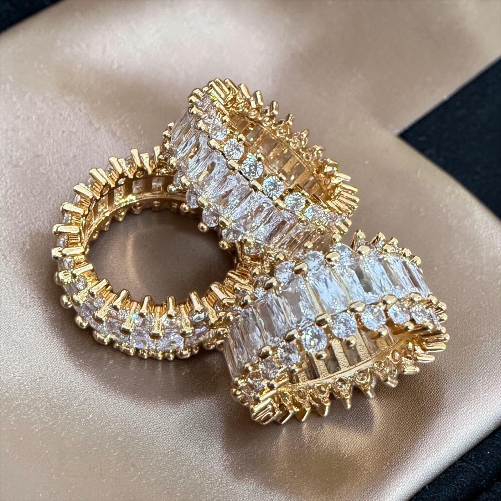 Anel  Aurora Imperial - aros 17 22 23 Descrição: Design imponente com pedras baguete lapidadas e microcravação luminosa que refletem sofisticação em cada detalhe. Uma peça marcante, feita para quem deseja presença e elegância em alto nível.
