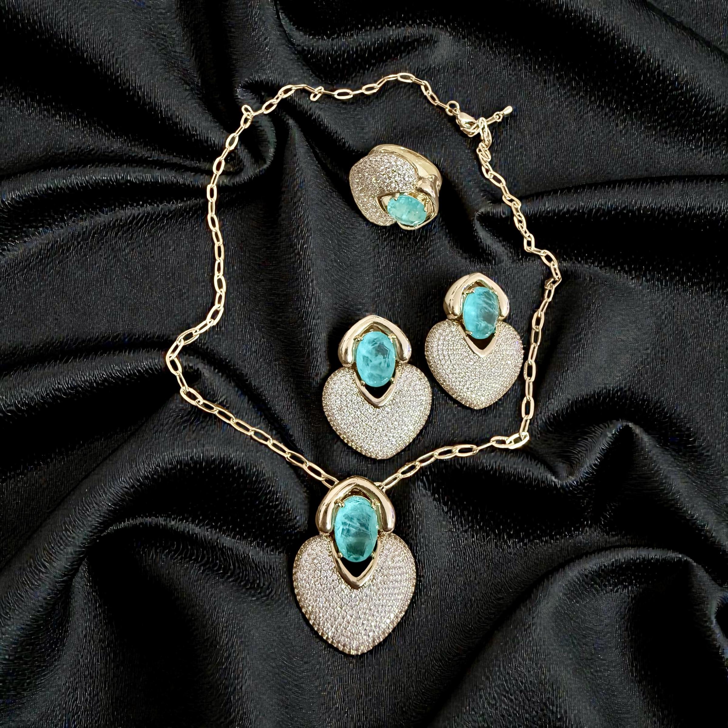 Conjunto Coração Esmeralda Imperial- anel aro 18 Descrição: 
Conjunto sofisticado com pedra verde vibrante sobre base cravejada, marcante e luxuoso.
