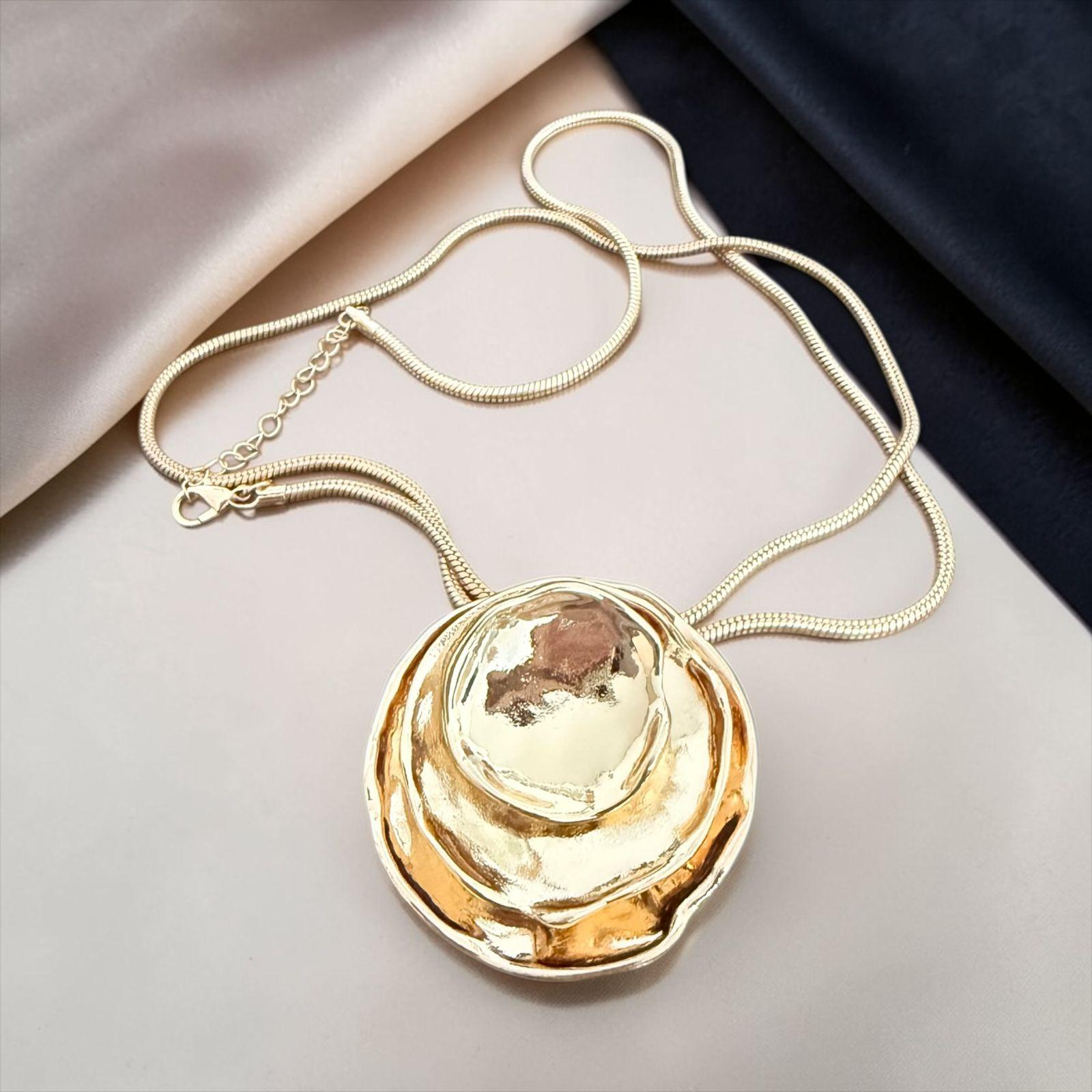 Colar Escultura Dourada Descrição: Colar extra longo. Design orgânico com formas fluidas e acabamento dourado espelhado que transmite sofisticação e exclusividade. Uma peça marcante, perfeita para composições elegantes com personalidade.
