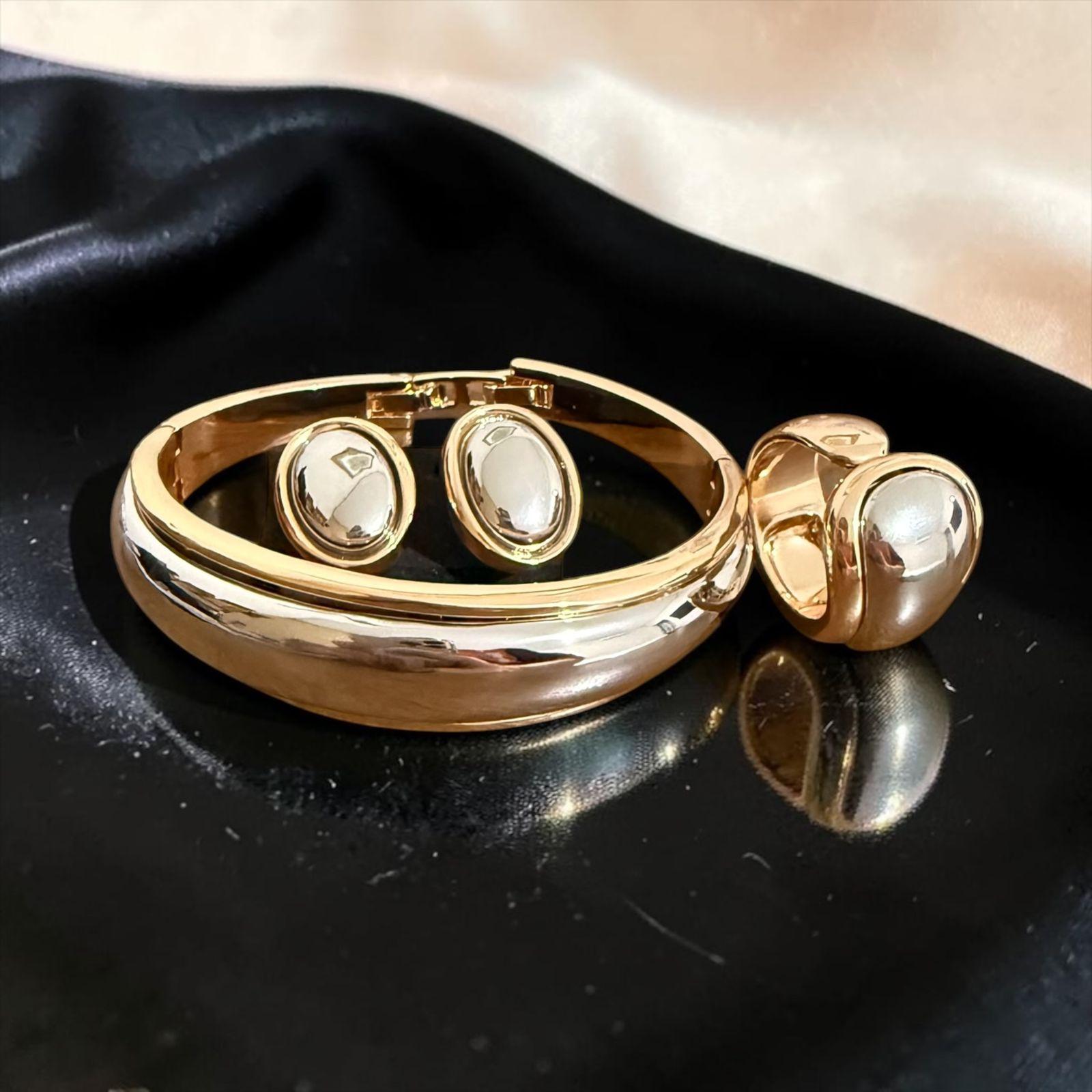 Conjunto Essenza Oval Descrição: Conjunto composto por bracelete, brincos e anel com design moderno e sofisticado, destacando formas ovais em acabamento polido de alto brilho. Uma composição elegante e minimalista, perfeita para quem busca um visual refinado, contemporâneo e cheio de personalidade.
