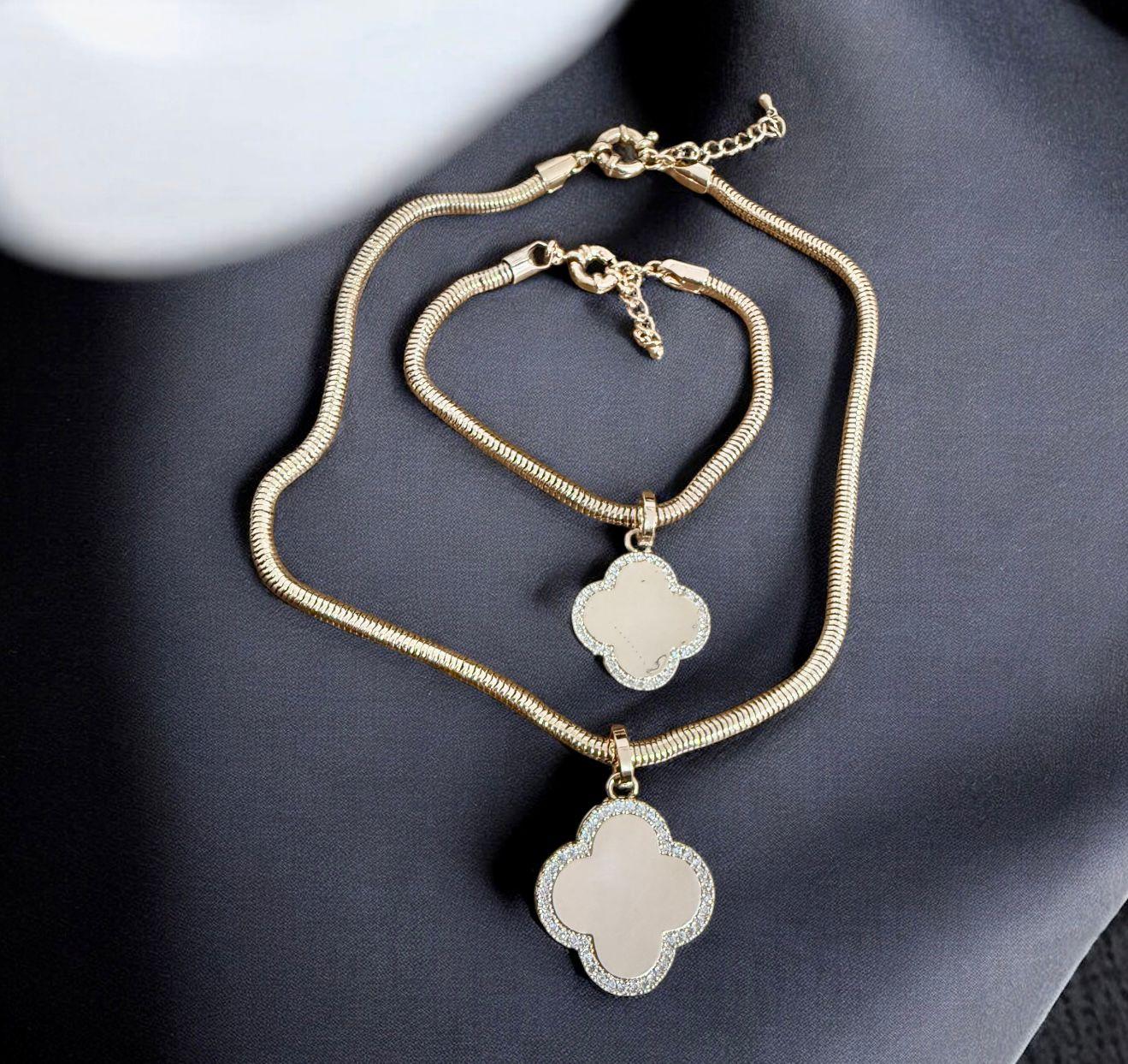 Conjunto Trevo Lux Descrição: Colar e pulseira com corrente dourada e pingente em formato de trevo com detalhe cravejado, que simboliza elegância e sofisticação.